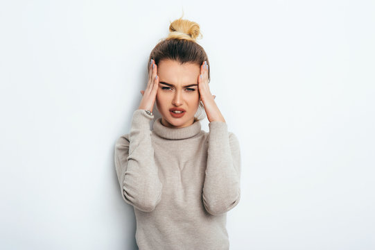 Close up isolated portrait of young stressed angry woman holding hands on head. Negative human emotions, headache face expressions. Ache Lifestyle Fashion Beauty People Business concepts.