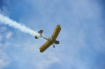 Vintage single engine propeller biplane aircraft flying against sky - bottom view