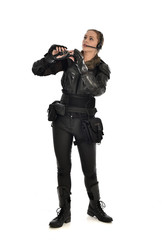 full length portrait of female  soldier wearing black  tactical armour  holding  a pair of binoculars, isolated on white studio background.