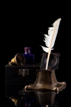 Ancient Inkwell, feather pen, old paper and a vintage bell