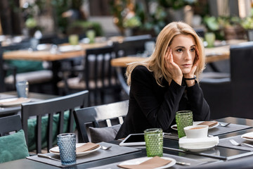 portrait of pensive woman waiting for someone in restaurant - Powered by Adobe