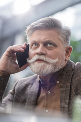 portrait of senior businessman talking on smartphone