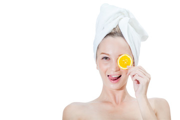 Beautiful young woman holding orange slices in front of her eye on face with a towel wrapped around head ,on white background with clipping path .spa and skin care