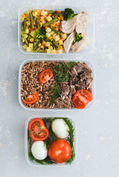 Diet food in the three containers on a gray background. Boiled and fresh vegetables, buckwheat, eggs, beef, chicken, dill.
