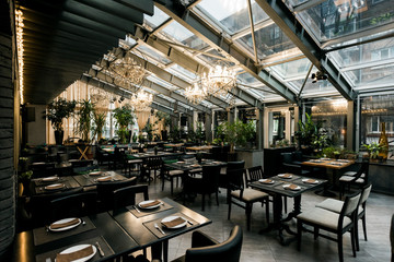 view of stylish empty cafe with arranged tables and chairs for visitors