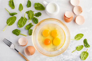 Raw ingredients for omelette with milk and spinach. Breakfast concept, top view, copy space.