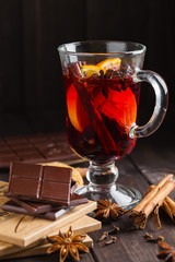Chopped bitter chocolate with glass of mulled wine and spices
