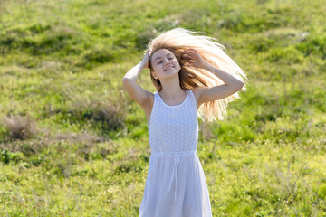 teenager girl is swaying her hair outdoor