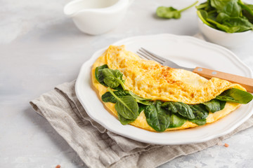 Omelette stuffed with spinach and cheese for a breakfast. Breakfast concept.