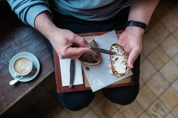 Midsection of man spreading butter on sourdough bread