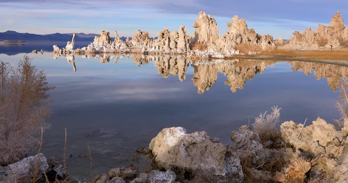 Mono lake tufas with reflection in calm water on sunrise with zoom in effect