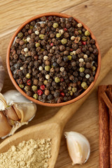 Composition of powder spices on spoon and different sorts of spicies on wooden table background, selective focus