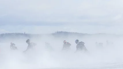 Schilderijen op glas Motorcyclist racing on ice track in the middle of whirling snow © Juha Saastamoinen
