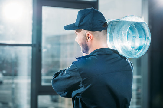 Rear View Of Loader Carrying Water Bottle On Shoulder