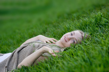 teen girl  lays on the grass