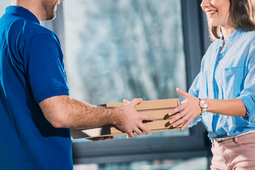 Obraz premium Woman receiving pizzas in boxes from delivery man