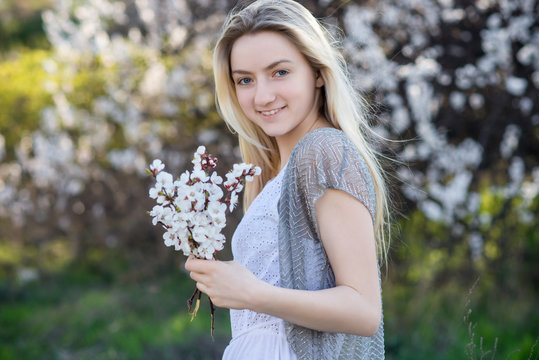 Teenage girl in blooming apricot garden