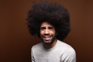 Fototapeta na wymiar Afro man in front of a brown background