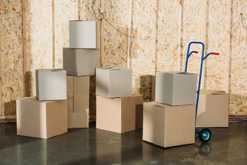 Cardboard boxes and hand truck in warehouse room
