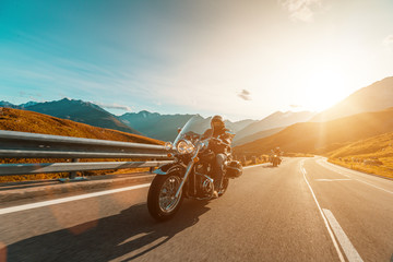 Naklejka premium Motorcycle driver riding japanese high power cruiser in Alpine highway on famous Hochalpenstrasse, Austria.
