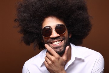 Afro man in front of a brown background