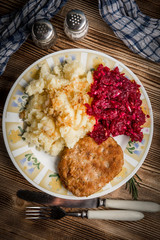 Pork cutlet with minced meat served with boiled potatoes and beetroot.