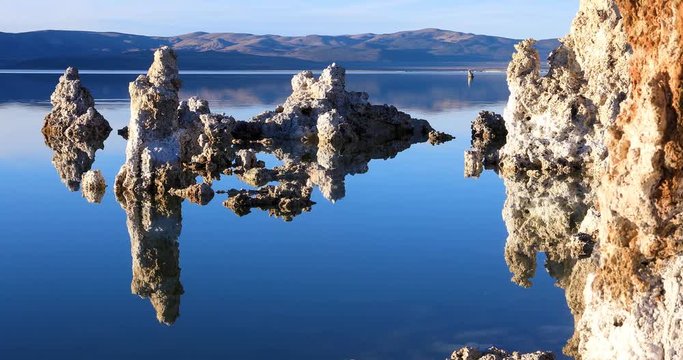 Mono lake tufas with reflection in calm water close-up on sunrise.