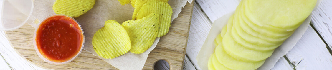 Horizontal bakground of potato chips on a table