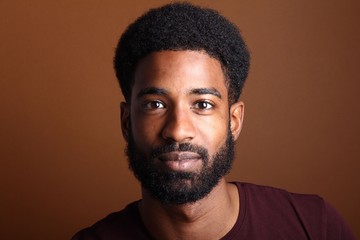 Obraz premium Afro man in front of a brown background