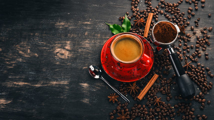 Hot coffee American in a cup. Cinnamon. On a black wooden background. Top view. Copy space.