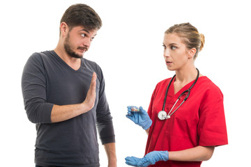 Male patient refusing female doctor with medicine.