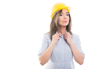Portrait of female constructor buttoning her shirt.