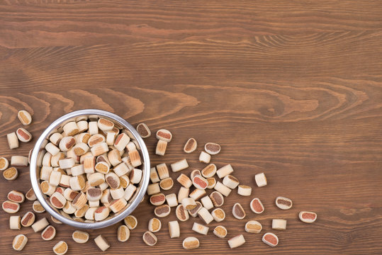 Dog food in a bowl on a wooden background with a copy space