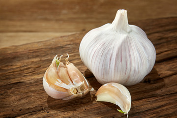 Garlic close up on wooden plate on rustic background, shallow depth of field, selective focus, macro