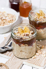 sweet oat pudding with jam and bananas, top view closeup