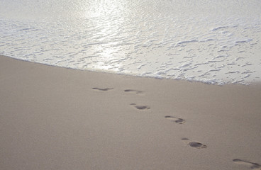 footprints imprinted on the sand coming out of the ocean