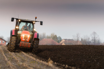 Fototapeta premium Tractor plowing fields -preparing land for sowing in autumn