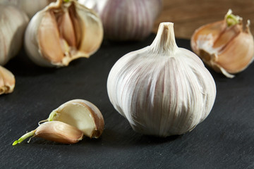 Garlic close up on wooden plate on rustic background, shallow depth of field, selective focus, macro