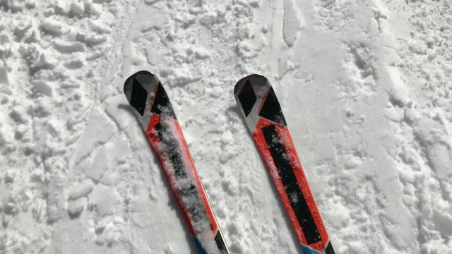 Above footage of legs on ski gliding fastly over snow trace
