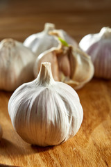 Garlic close up on wooden plate on rustic background, shallow depth of field, selective focus, macro