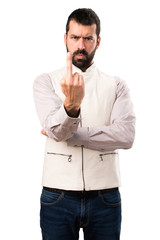 Handsome man with vest making horn gesture on isolated white background