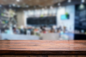 Selected focus empty brown wooden table and Coffee shop or restaurant blur background with bokeh image. for your photomontage or product display.