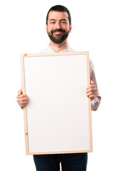 Handsome man with vest holding an empty placard on isolated white background