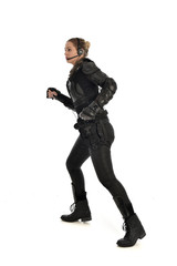 full length portrait of female  soldier wearing black  tactical armour, isolated on white studio background.
