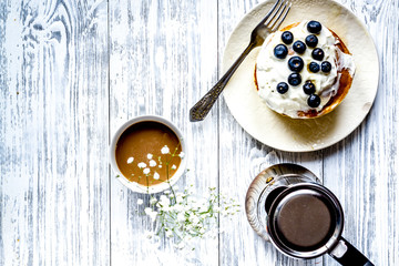 Breakfast concept with flowers on wooden background top view