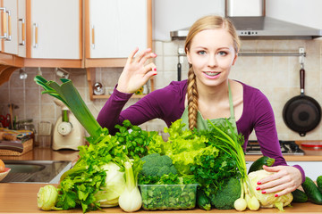 Woman in kitchen with green vegetables