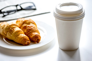 Breakfast for businessman with coffee and croissant on white tab