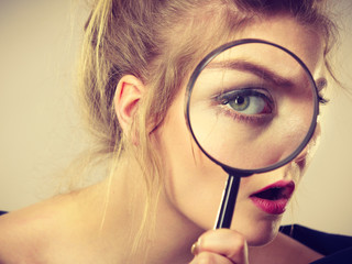 Woman holding magnifying glass investigating