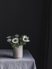 Anemonen und Eukalyptus vor schwarzer Wand