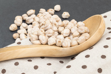 wooden spoon full of chickpeas on a rag